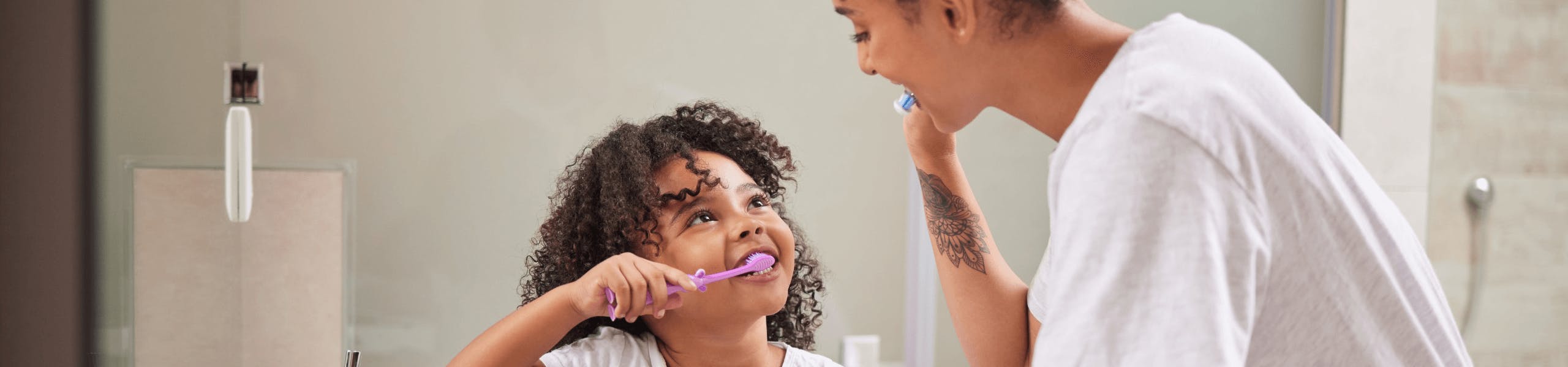 Mother and daughter brushing their teeth together