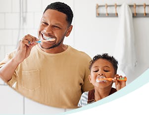Father and son brushing teeth together