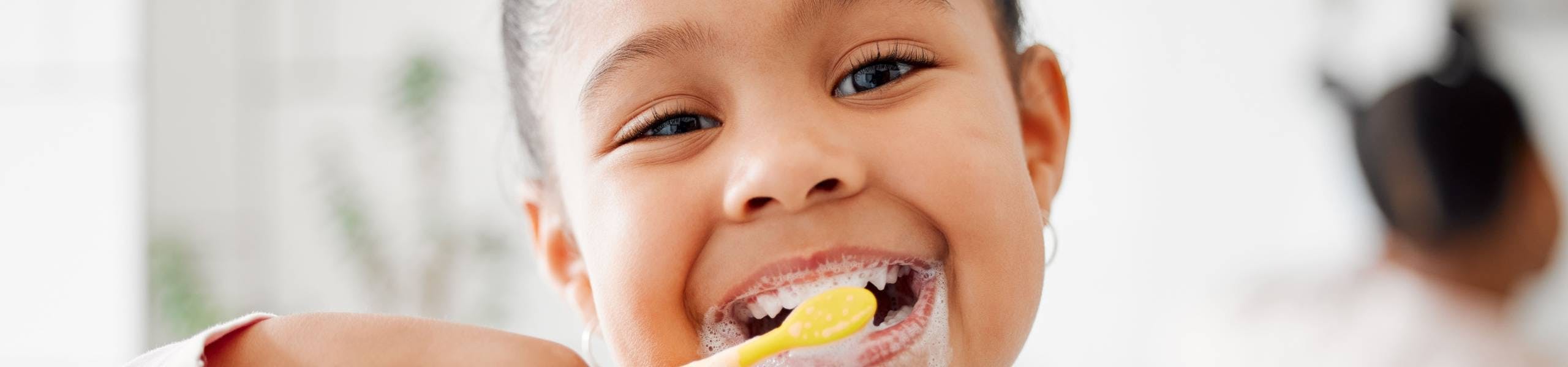 Child smiling and brushing teeth