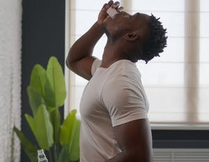 Man using mouthwash in bathroom