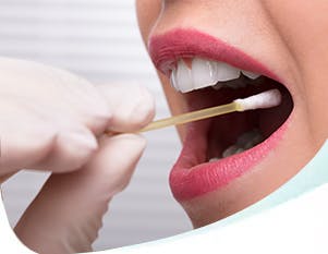 Person taking a swab test of woman’s mouth. 