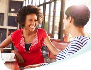 Two women sitting on chairs and having a friendly talk 