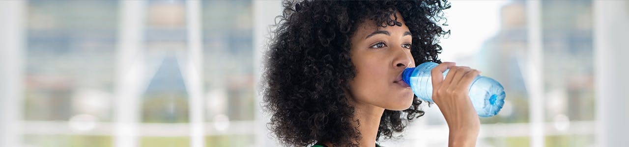 Femme buvant de l'eau en bouteille