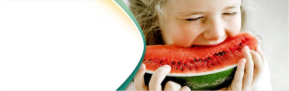 Little girl biting into a slice of watermelon