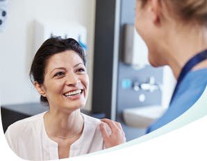 Femme souriante parlant à une professionnelle des soins dentaires