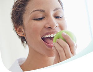 Femme croquant une pomme verte
