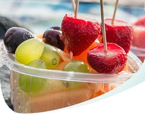 Deux contenants remplis de fruits acides : fraises, raisins, melon d’eau