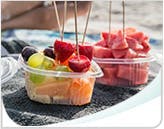 Deux contenants remplis de fruits acides : fraises, raisins, melon d’eau Deux contenants remplis de fruits acides : fraises, raisins, melon d’eau