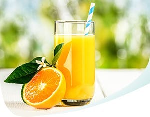 Du jus d'orange dans un verre et une moitié d'orange à côté