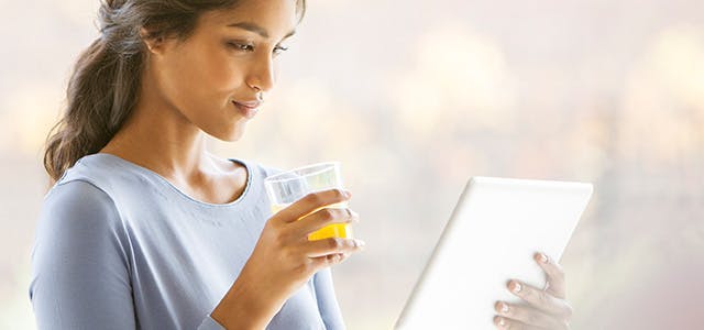 Femme buvant du jus acide en lisant