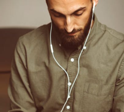 Man in a green shirt listening to headphones