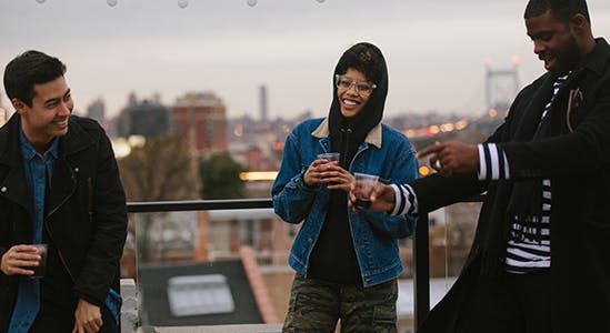 3 friends hanging out on a rooftop patio