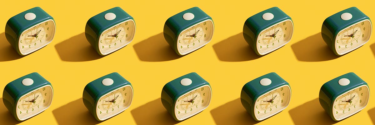 Alarm clocks in a repeating pattern on a yellow background