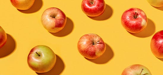 Apples in a repeating pattern on a yellow background Apples in a repeating pattern on a yellow background