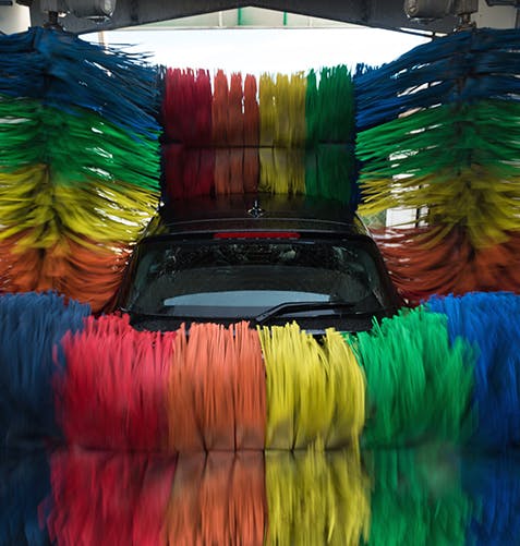 Voiture dans un lave-auto aux couleurs de l’arc-en-ciel