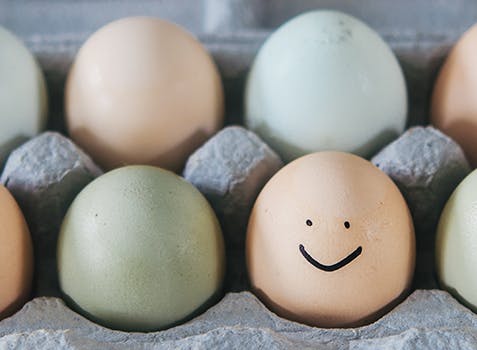 Boîte d’œufs; sur l’un d’eux est dessiné un visage souriant