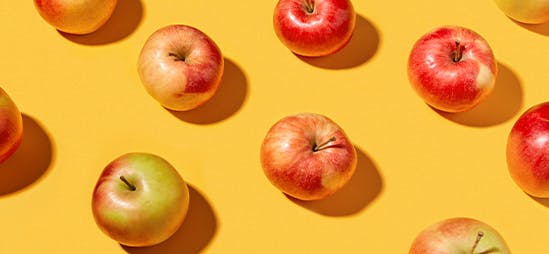 Motif répétitif de pommes sur fond jaune