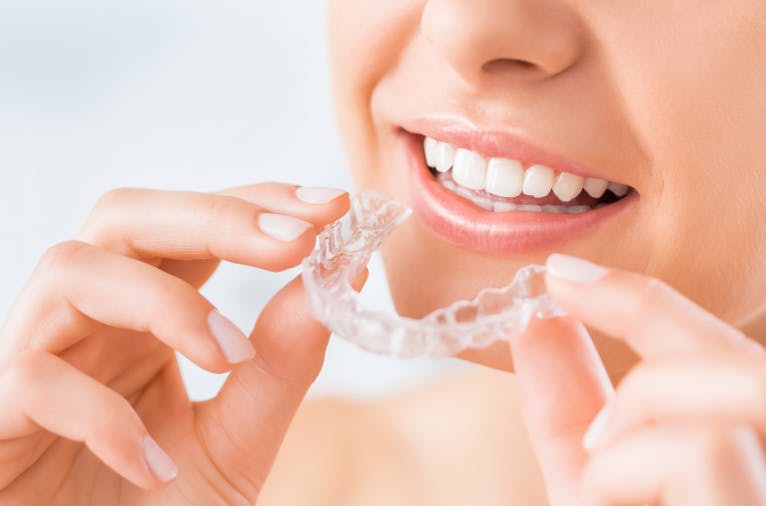 Woman using at home tooth whitening treatment for sensitive teeth