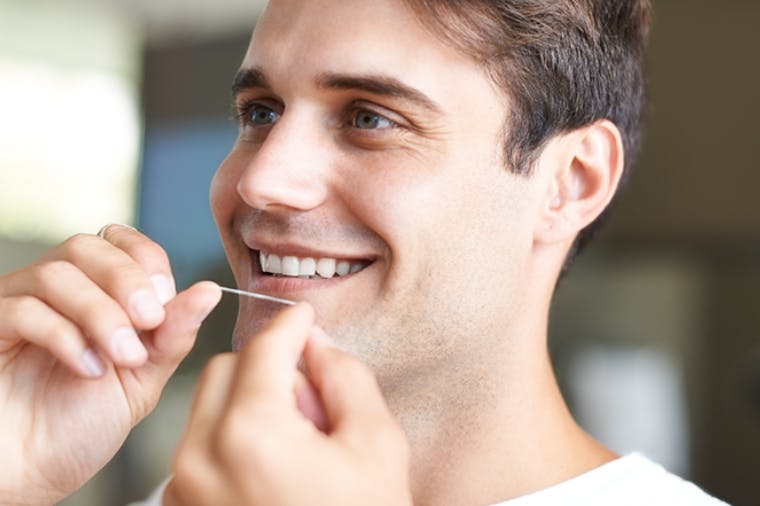 Man with tooth sensitivity to cold flossing