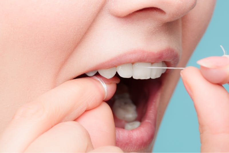 Woman flossing her sensitive teeth