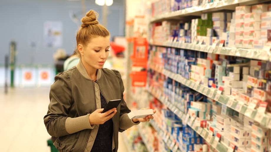 Woman reads toothpaste label while shopping