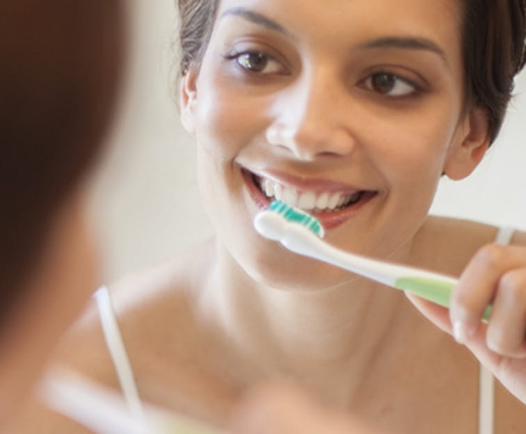 Woman using Sensodyne True White to whiten her sensitive teeth