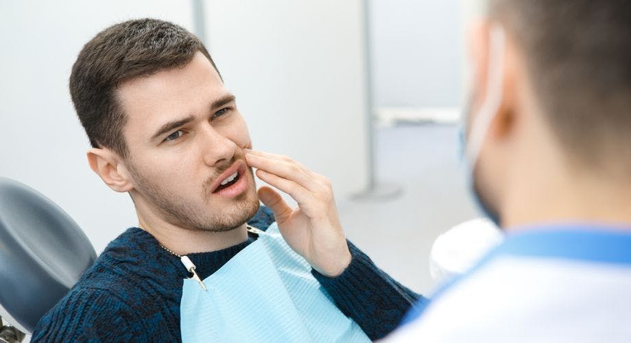 Young man at the dentist has a toothache