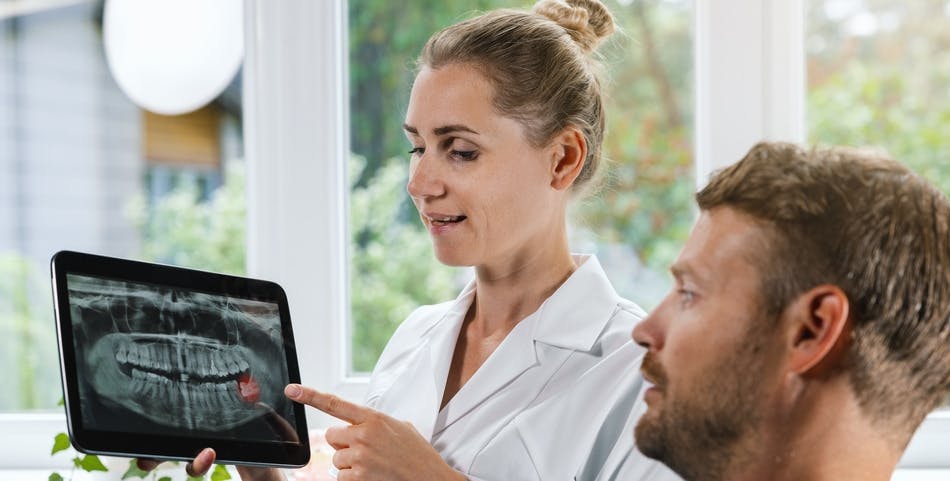 Dentist showing patient an x-ray of his teeth