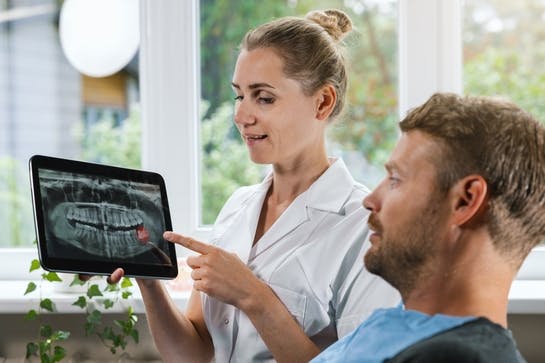 Dentist showing patient an x-ray of his teeth