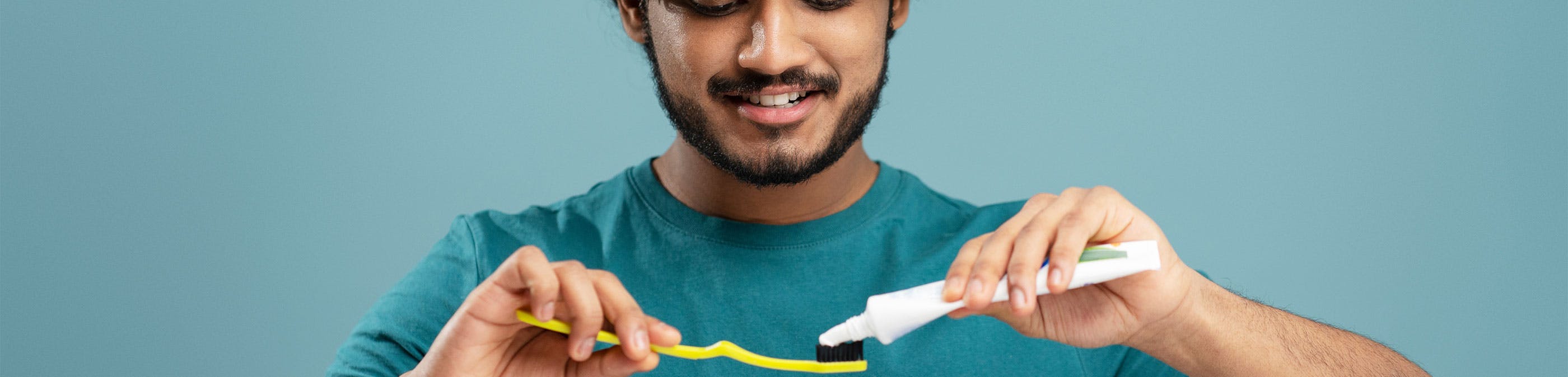 Man applying toothpaste to toothbrush