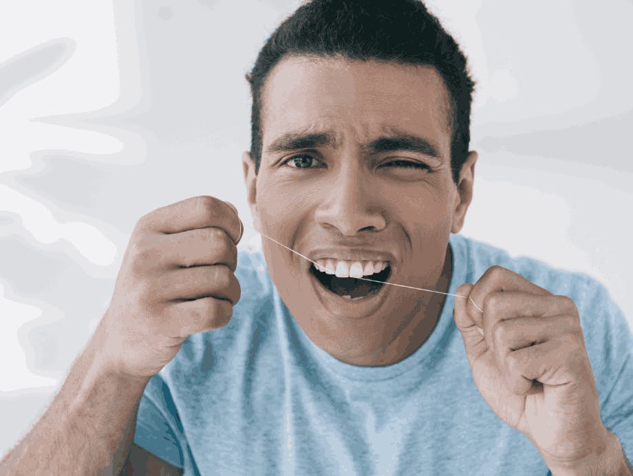 Man in pain while flossing