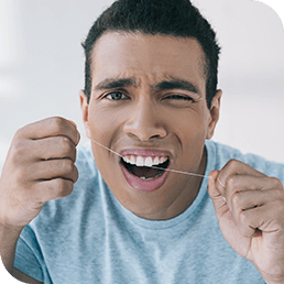 Man hurting his teeth after floss
