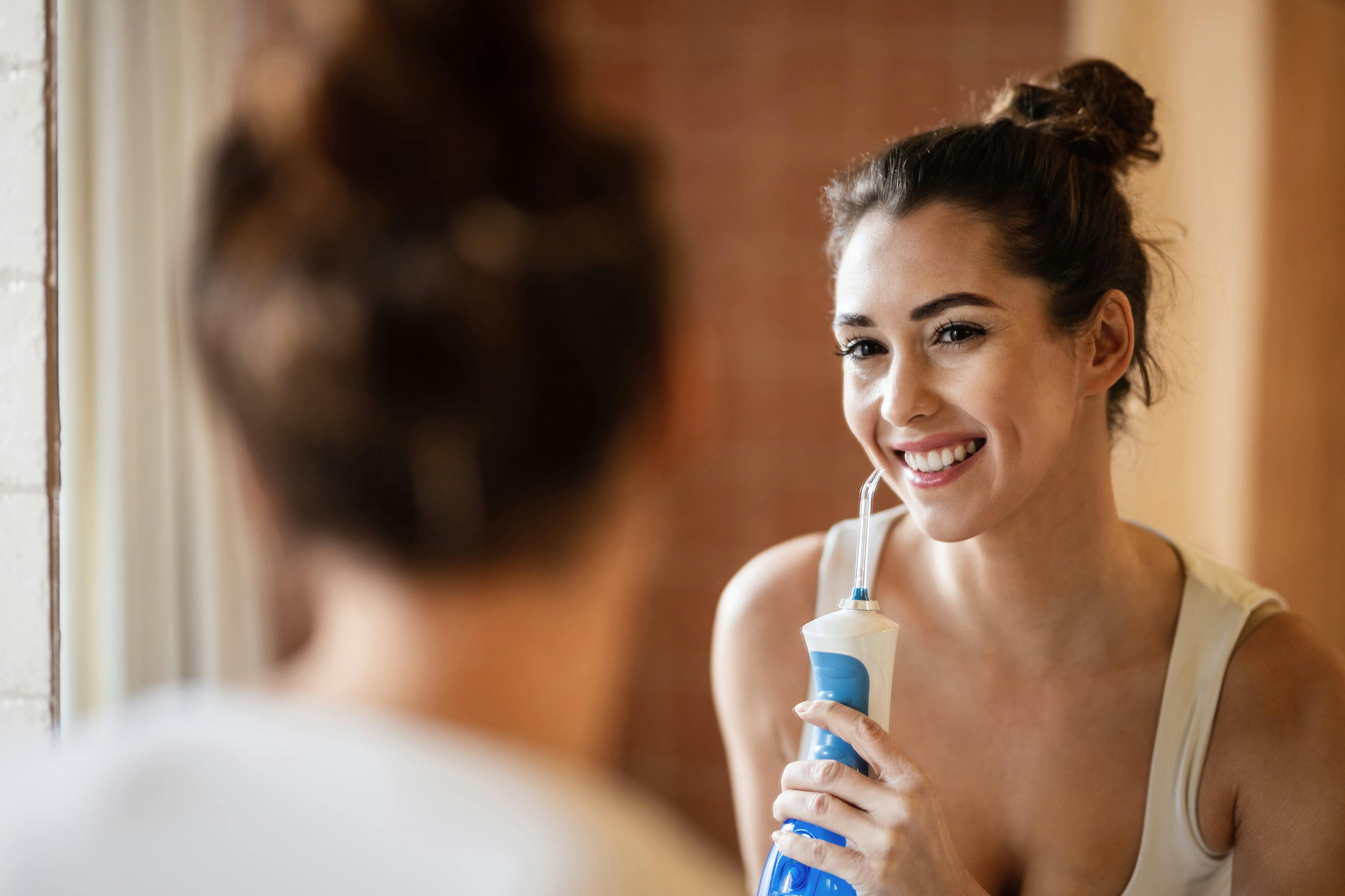 A woman using a water flosser