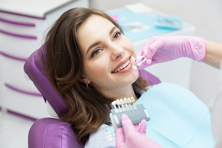 woman in dentist office receiving teeth whitening procedure