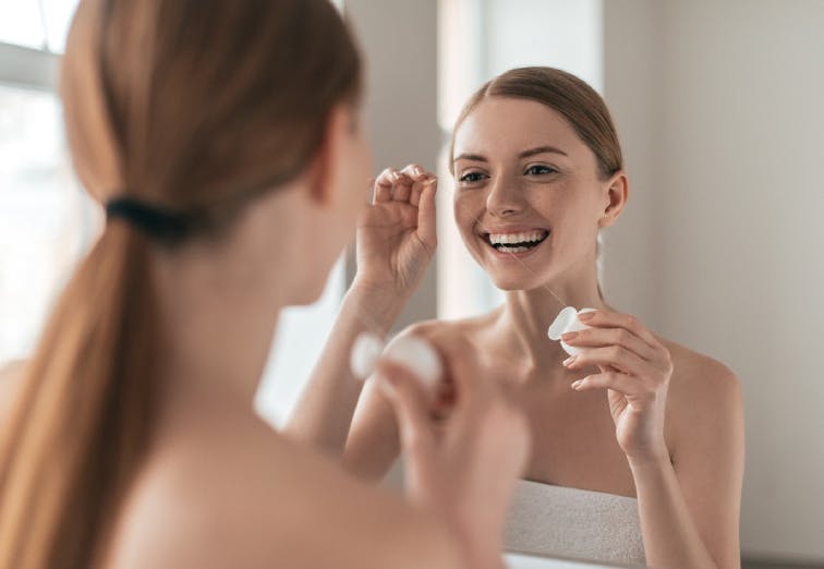 Woman flossing her teeth