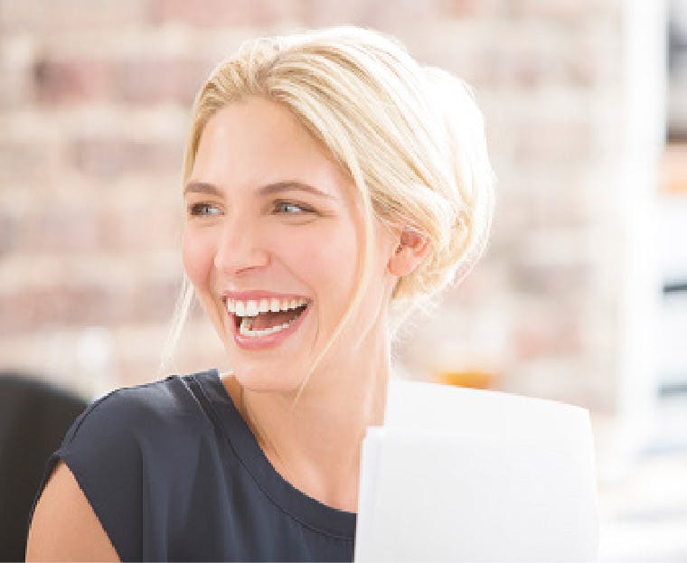 Mujer sonriente porque acaba de terminar de blanquear sus dientes sensibles