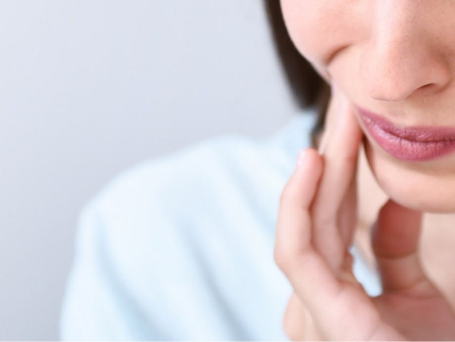 Mujer experimentando dolor de dientes - Sensodyne ES