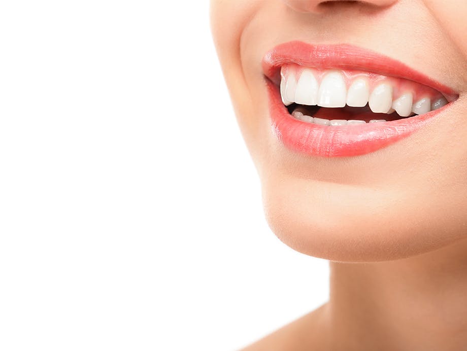 Nainen hymyilemässä valkoisilla hampailla