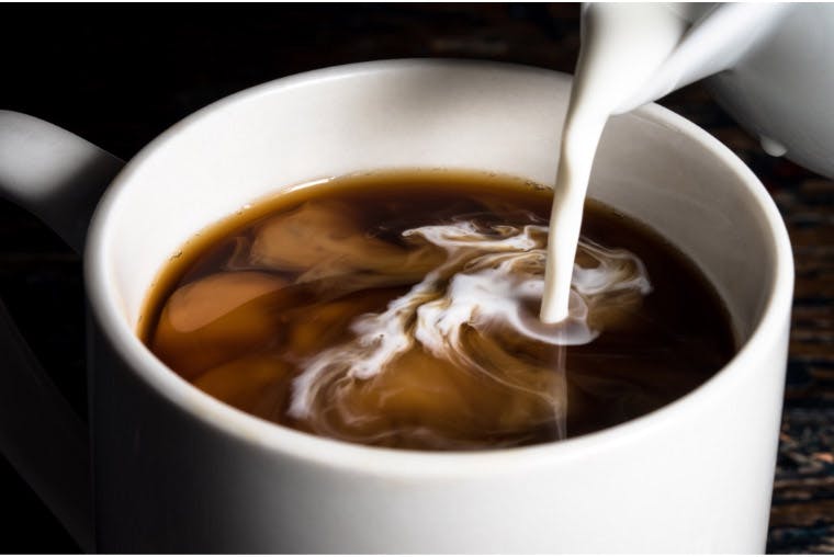 En kopp kaffe som tilsettes melk