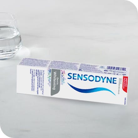 Sensodyne tannkrem og pakning som ligger på en benk
