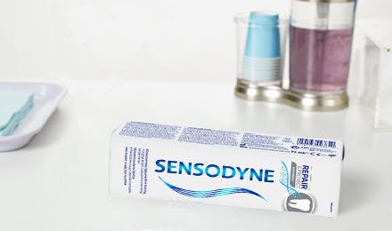 Sensodyne Repair and Protect pakning og tannkrem som ligger på et baderomsmøbe