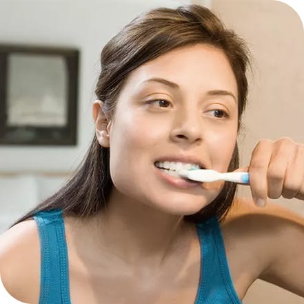 Kvinne som pusser tennene for å opprettholde sunne tenner