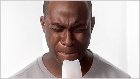 Man biting on ice with sensitive teeth