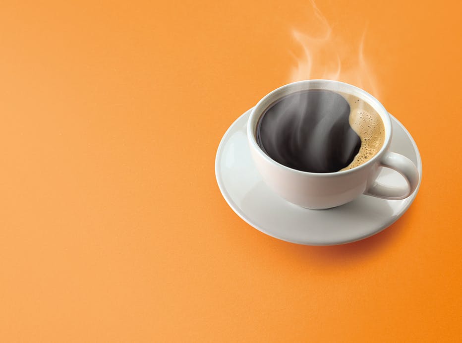 A mug and saucer of black coffee