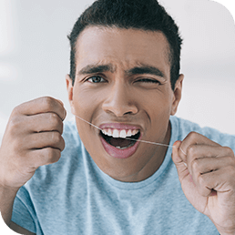 Man in pain while flossing