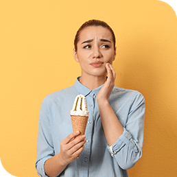 A white woman experiencing sensitive teeth with ice cream