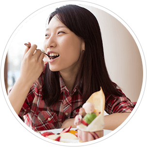 Femme durant sa pause-déjeuner. Même les aliments sains peuvent causer une érosion dentaire.