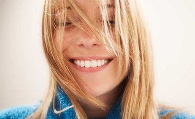 Young blonde woman smiling with closed eyes