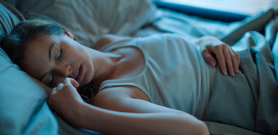 Young Woman sleeping in a bed | Ban electronic screens from the bedroom.