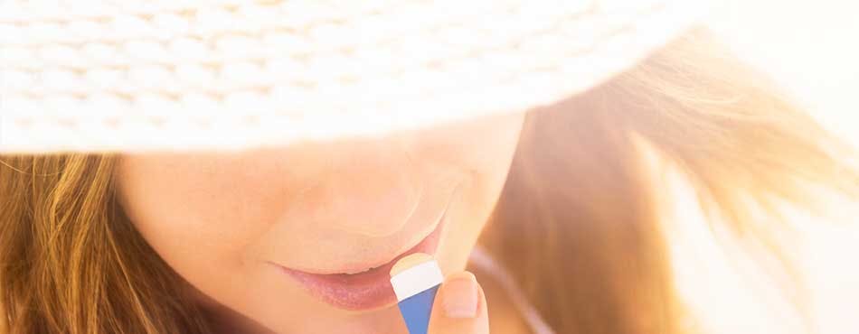 Woman applying Abreva lipstick Woman applying lip balm